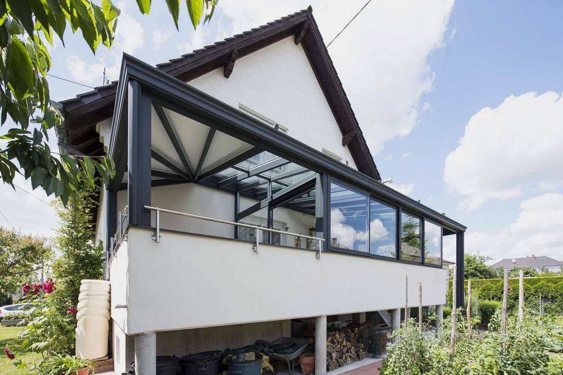 Véranda surélevée moderne en verre et aluminium pour maison lumineuse